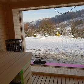 fínska sauna s veľkým oknom a výhľadom na prírodu